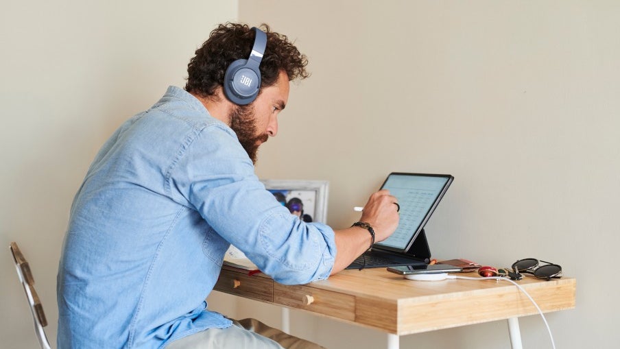 A man wearing headphones and working on his laptop.