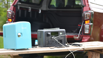 Bluetti EB3A with multiple devices connected to it, including a small refrigerator, placed on a wooden table.