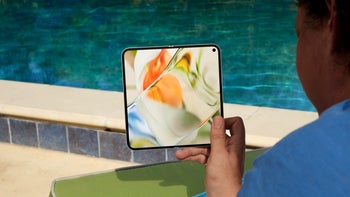 Person sitting poolside holding up a Pixel 9 Pro Fold