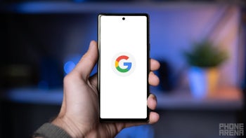 A person holding up an Android phone with the Google app logo displayed