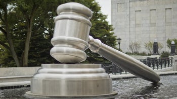 Statute of a judge's gavel hitting a sound block on display to the public.