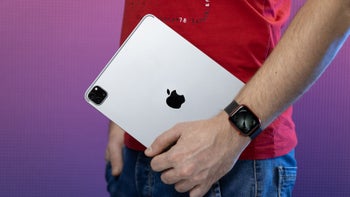 A close-up shot of a person holding the 11-inch iPad Pro (2022), showing its rear side.