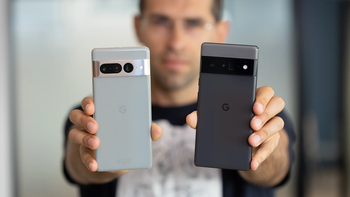 A person holding two Google Pixel phones in front of him.