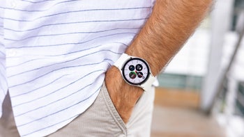 A close-up of a man's hand wearing the Galaxy Watch 6 with a white band.