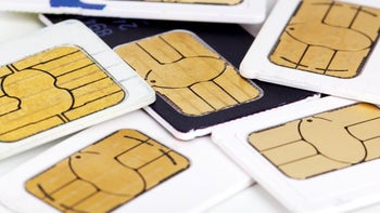 Physical SIM cards from various devices are laid out on a table.