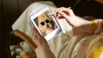 A person sitting down editing a photo of a dog on a Samsung Galaxy Z Fold device with an S Pen