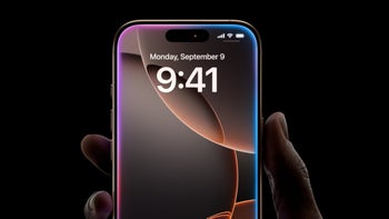 iPhone 16 Pro Max is held with a dark background as the Siri "lights" glow along the edges of the device.