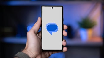 Google Messages logo on a smartphone with blurred background.