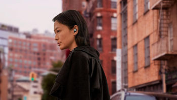 A woman wearing Pixel Buds Pro on a city street.