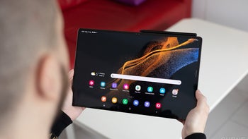 A person holding the Galaxy Tab S8 Ultra with the screen on.