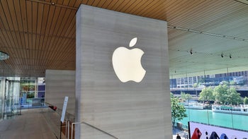 The iconic Apple logo in white is seen on a column at an Apple Store,