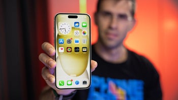 The iPhone 15 with its display towards us held by a person.