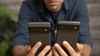 An image of a man holding two phones in his hands