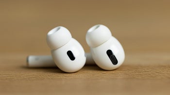 The AirPods Pro 2 earbuds on a wooden surface.