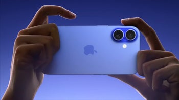 Hands holding an ultramarine iPhone 16 in landscape mode with the cameras facing towards the viewer