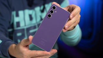 A close-up of two hands holding the Galaxy S23 FE, showing its Purple back color.