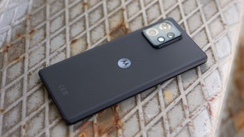 The Motorola Edge+ (2023) showing its back with the M logo, placed on a metal stair-textured background.