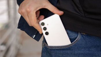 Inserting white Samsung Galaxy S24 into pants pocket