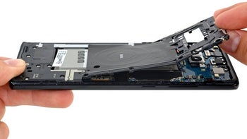 A close-up showing how a man is taking apart a Samsung smartphone.