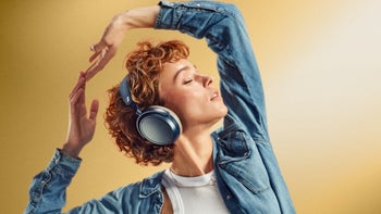 A woman listening to music with Sennheiser Momentum 4 headphones.