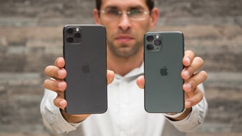 PhoneArena's Vic is holding an iPhone 11 Pro Max in the right hand with the iPhone 11 Pro in his left hand and we see the back of both models.