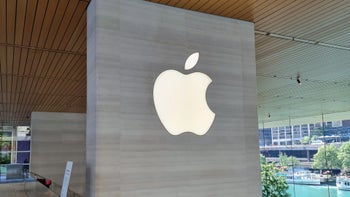 Apple logo displayed on a grey wall.