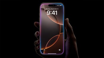 A neon-like iPhone 16 held on a black background.