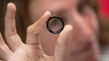 Galaxy Ring held by a woman, with a blurred background.