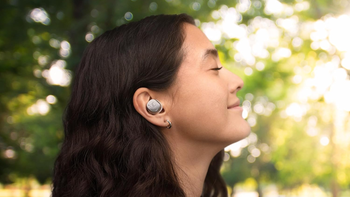 Side profile of a woman with closed eyes, wearing the Sennheiser Momentum True Wireless 4 in an outdoor setting.