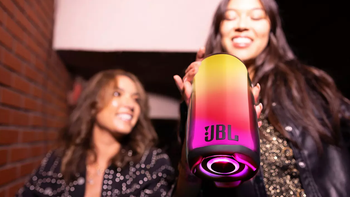 Two girls, one holding a colorful JBL Pulse 5 speaker