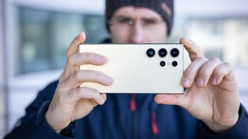 PhoneArena's Vic holds the Galaxy S24 Ultra with the rear cameras facding out in landscape mode.