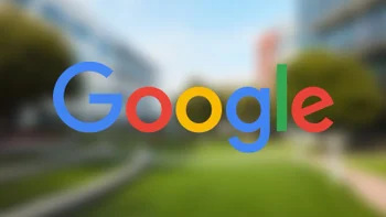 The Google wordmark in blue, red, yellow, and green is in the foreground while the Google campus is softly out of focus in the background.