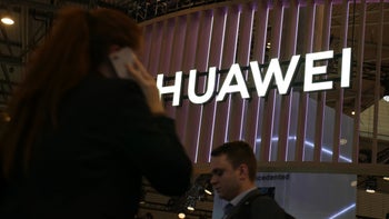 Huawei logo is seen as lighted letters appear on a building at night.