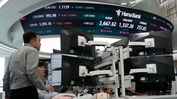 A foreign exchange dealing room is seen with a ticker tape showing the latest quotes and traders watching the action.