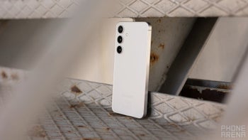 A white Samsung Galaxy S24 smartphone resting on a set of metal steps.