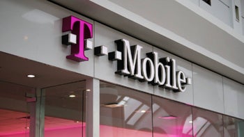 A T-Mobile sign on the top of the entrance to a retail location with a magenta "T" and the rest of the lettering in white.