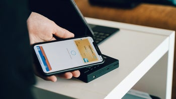 A phone with mobile payments held by a person.