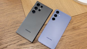 Two Samsung phones layed screen facing downwards on a table.