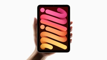 An official image of someone's hand holding up an iPad Mini