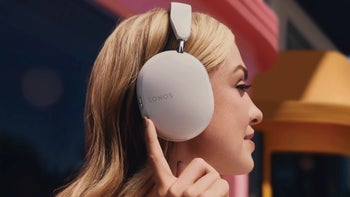 An image of a person wearing Sonos Ace headphones while using its volume controls