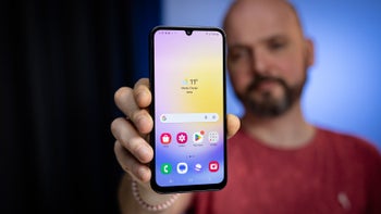 A close-up of a person holding the Galaxy A25 5G against a blurred background, showing the home screen with app icons.