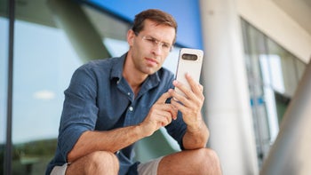 A sitting person holding a Pixel Phone and working on it.