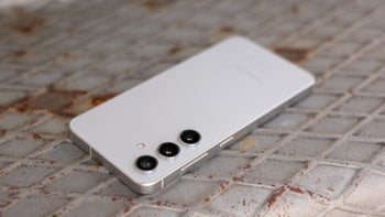 A Samsung Galaxy S24 is placed on a patterned metal surface, showing its rear design.