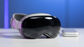 Apple Vision Pro headset displayed over a table with its charging case next to it.