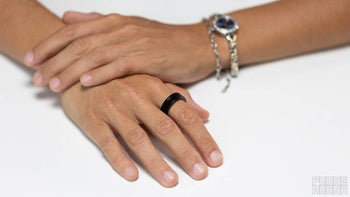 The Galaxy Ring on a finger of a person on a white background.