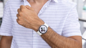 A man in a white striped shirt wearing the Galaxy Watch 6 with a white strap on his left wrist.