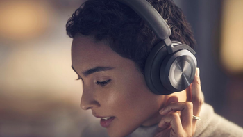 A woman listening to music with a pair of  Bang & Olufsen Beoplay HX headphones