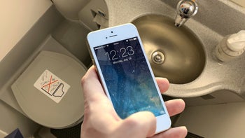 An iPhone 6s Plus is held inside an airplane lavatory.