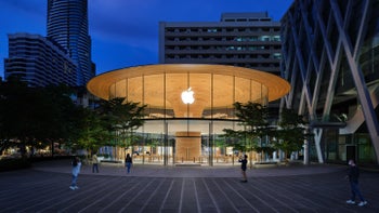 Glass Apple store photographed at night with glowing Apple logo.