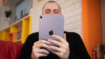 A person holding an iPad Mini 6 with both hands